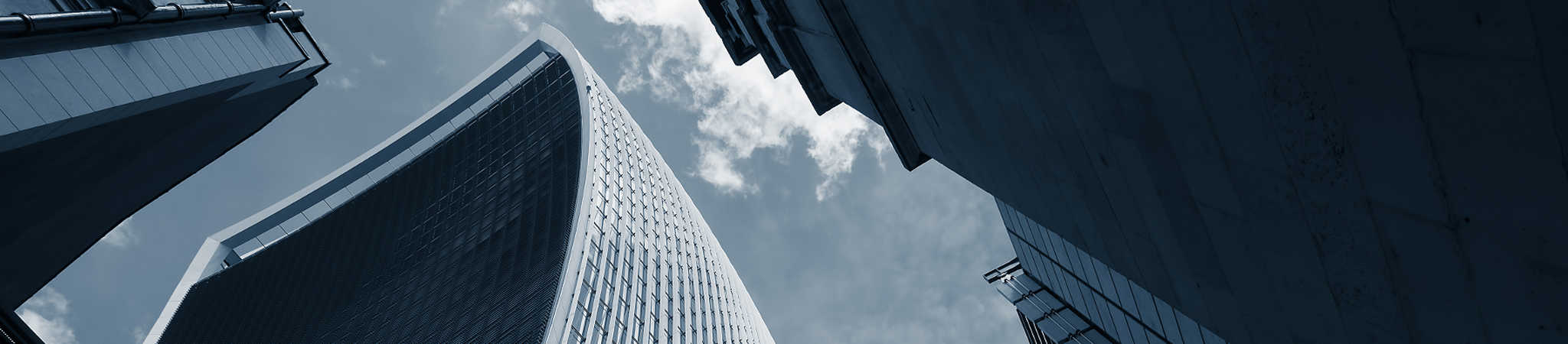Commercial skyscrapers stretch upward on a sunny day. This image symbolizes business law.