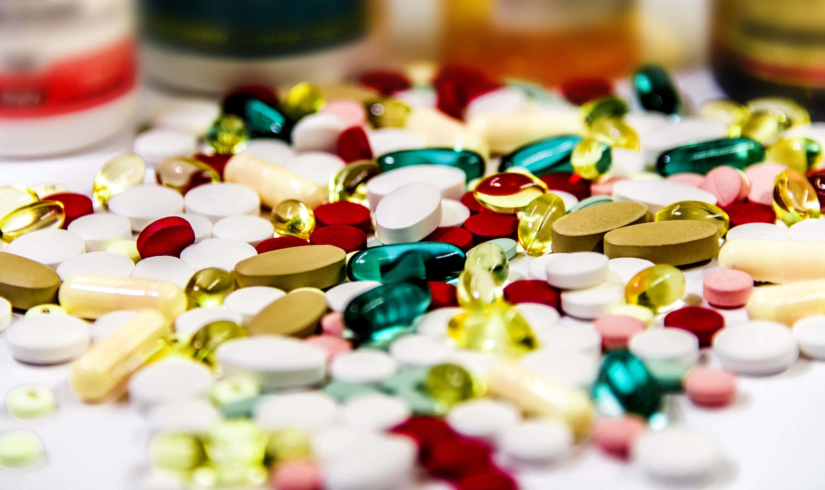 Various pills are spilled out on a counter.