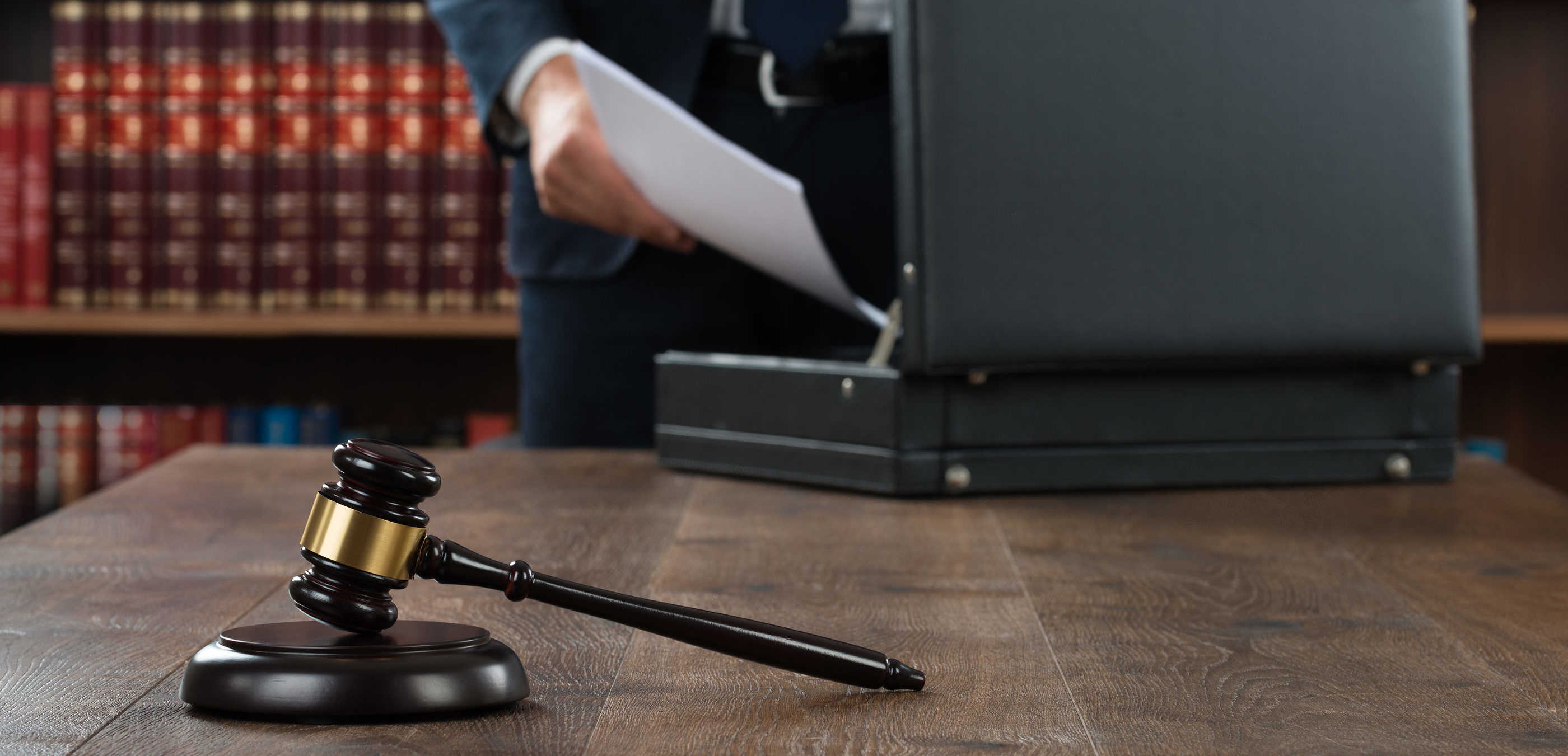 A lawyer puts documents in a briefcase.