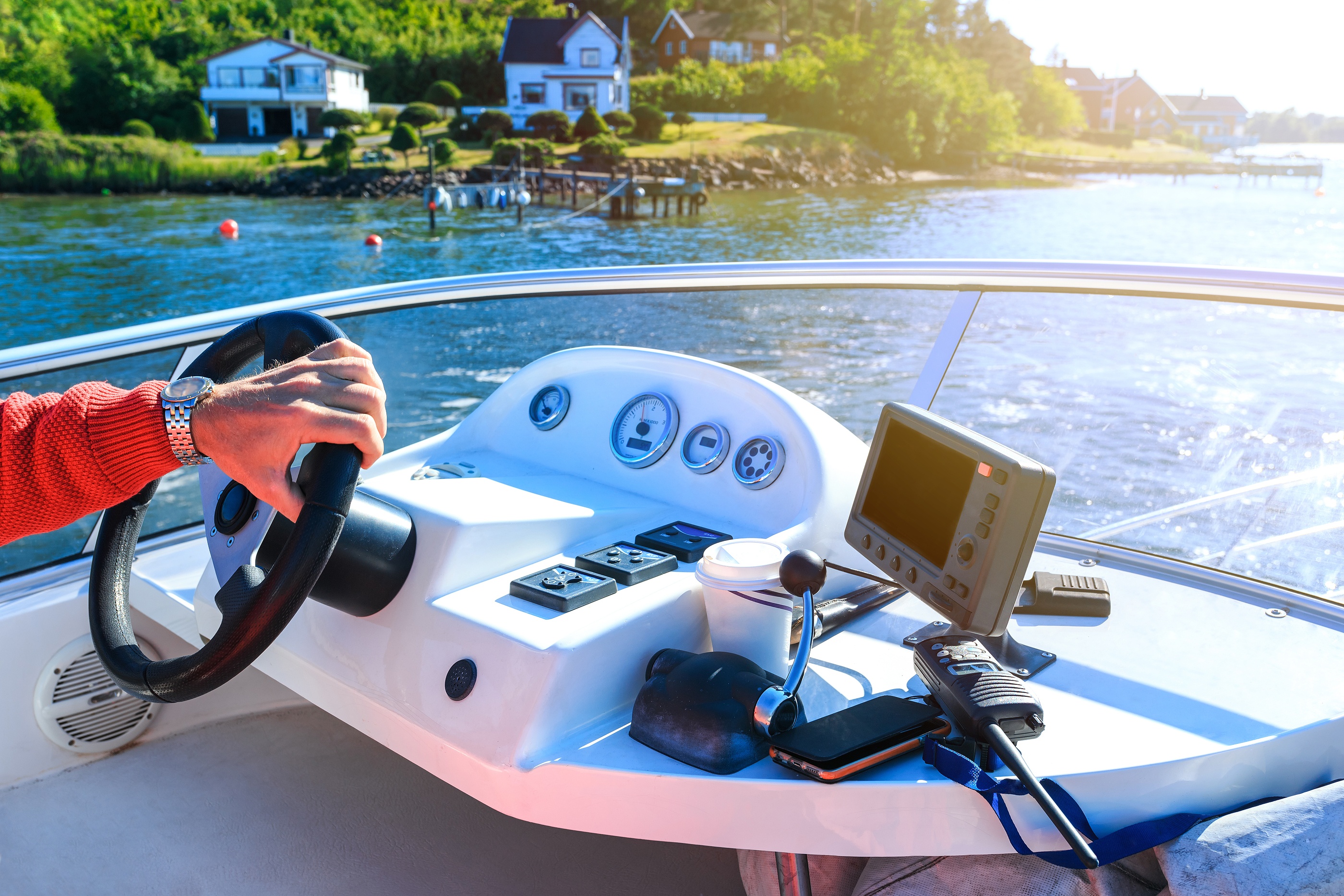 A person pilots a boat on a lake.