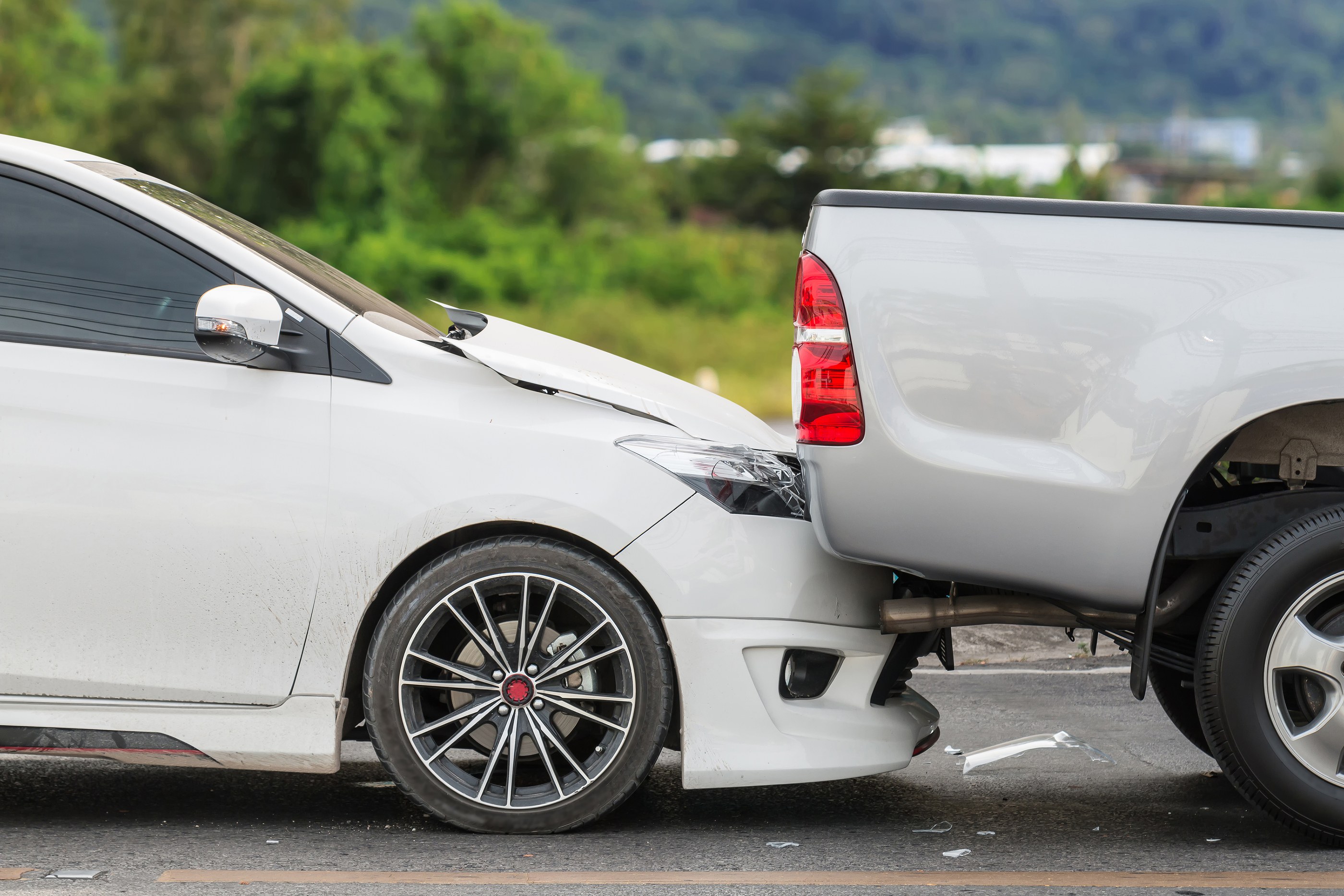 A car rear-ends a truck, causing a car accident.